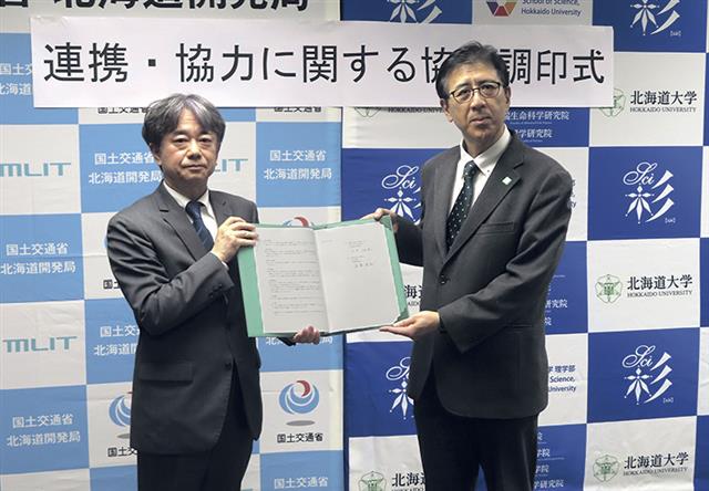 協定書を手にする遠藤局長（左）と永井理学研究院長