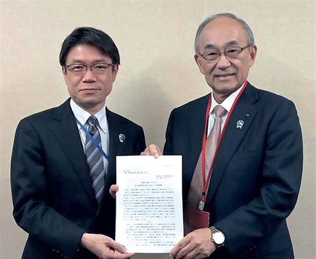 楠田局長（左）に要望書を手渡す井上委員長