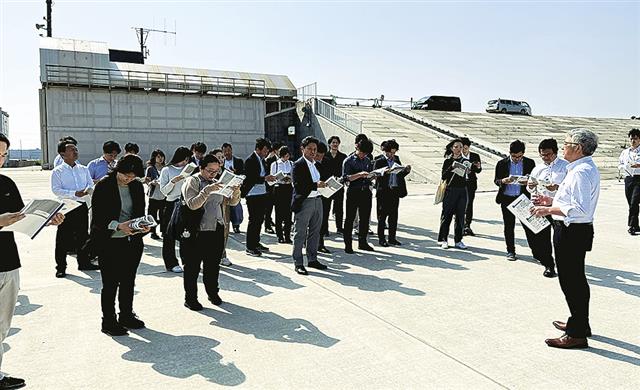 旧北上川の堤防（右側）、陸閘（左側）前での学習会