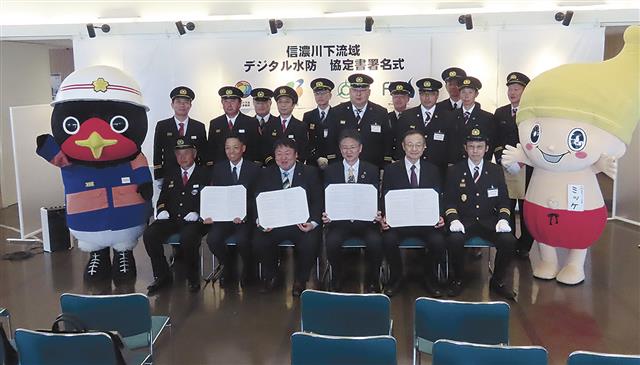 協定書を掲げる（左から）栗林所長、佐野市長、稲田市長、池内理事長