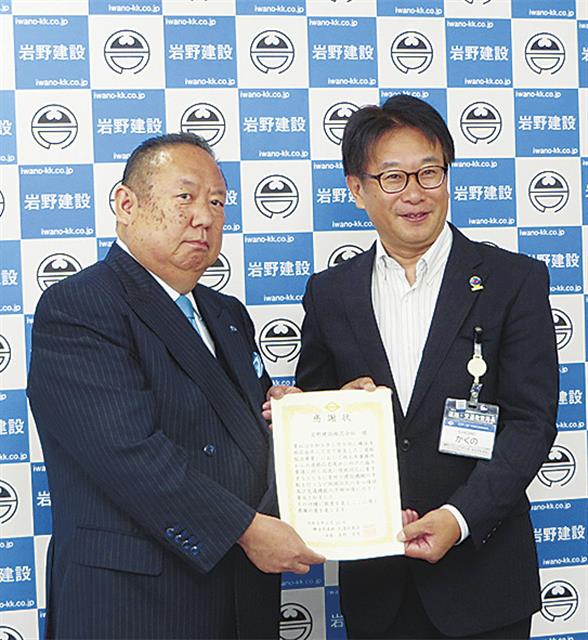 角野智史局長から賞状を受け取る岩野代表取締役（左）
