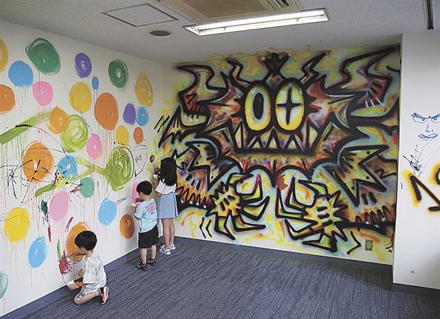 壁面にペイントする子どもたち