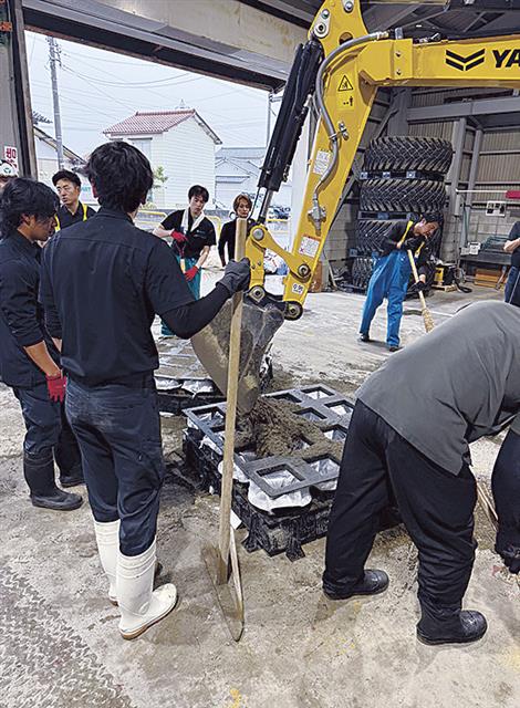 早朝から土のうづくりを進める吉光組社員　　　