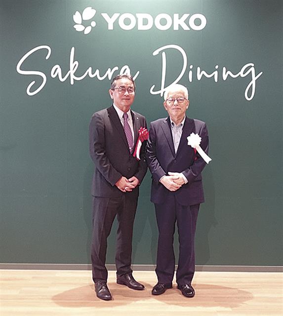 食堂で記念撮影する田中社長（左）と福島理事長