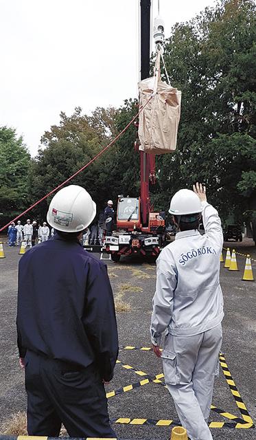 生徒が操縦するクレーンに合図する生徒