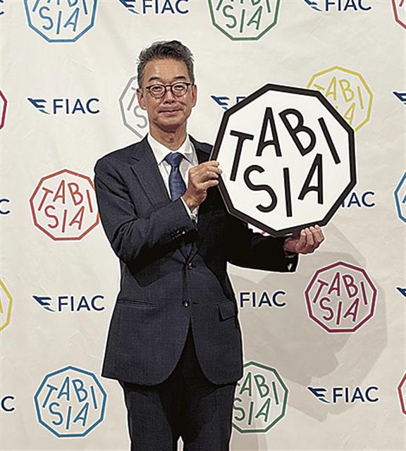ロゴを掲げる田川社長
